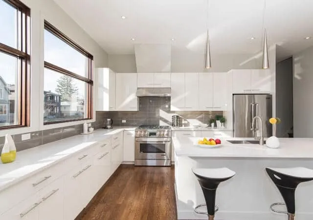 Bright kitchen and dining space with large windows and a central island